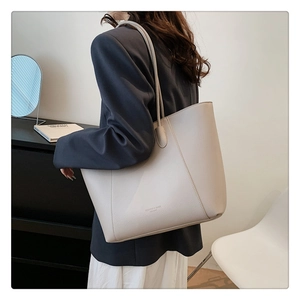 Détail du grand sac cabas blanc cassé avec texture cuir grainé et logo de la marque