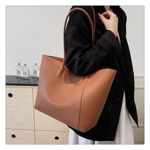 Vue détaillée de la texture de cuir litchi de qualité sur le grand sac cabas marron
