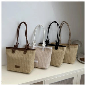 Detail of four woven tote bags in brown, white, black, and beige with knotted rope straps