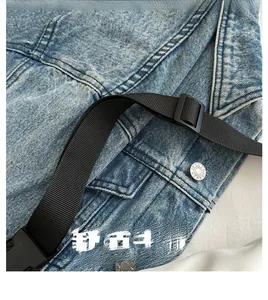 Detail van blauwe gewassen denim heuptas met stoftextuur en verstelbare gesp