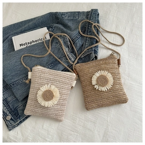 Detail of straw bags with 3D sunflower decor, zipper closure and slim rope straps