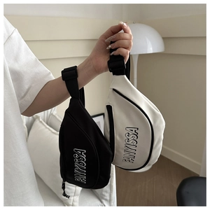 Detail van verstelbare banden en letteropdruk op zwarte en witte crossbody tassen