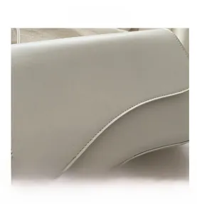 Close-up of a white leather crossbody bag showing fine texture and clean curved flap design