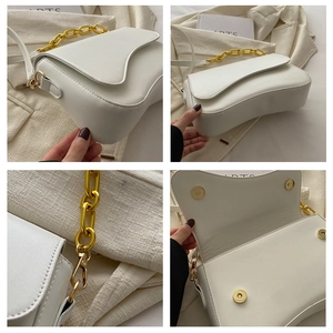 Detail view of white saddle bag showing gold chain, magnetic closure and strap hooks