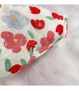 Close-up of floral tote bag fabric showing red flower print and soft textile texture