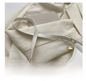 Close-up of white quilted handbag with golden zipper details and soft texture
