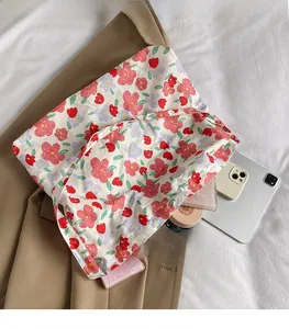 Flat lay of floral canvas tote bag showing spacious interior with daily essentials and tablet