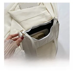 Quilted white shoulder bag interior showing capacity for phone and wallet with zipper