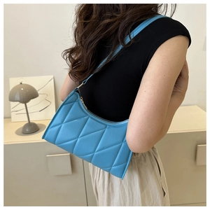 Detailed view of sky blue quilted underarm bag showing diamond stitching and PU leather texture