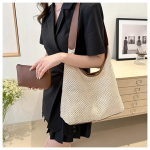 Détail du sac hobo tissé beige avec bordure en cuir marron et pochette assortie