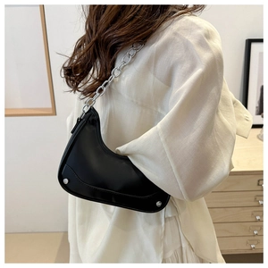 Detail of minimalist black hobo bag with silver studs and thick metal chain strap