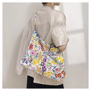 Detail showing high-capacity nylon floral crossbody bag with vibrant wildflower pattern