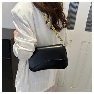 Detailed side profile of a black crossbody bag with wave design and gold chain strap