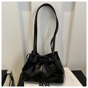 Dettaglio della borsa a spalla nera con fiocco e texture in pelle sintetica liscia