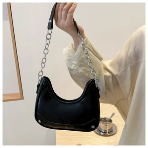 Detail of black hobo bag with smooth leather finish and silver chain strap accent
