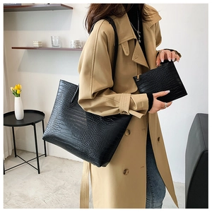 Detail of black crocodile pattern tote bag set including a matching zipper clutch purse