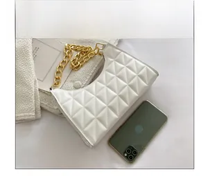 Size comparison between white quilted handbag with gold chain and a smartphone