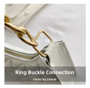 Close-up of white quilted leather texture with gold metal chain link buckle detail