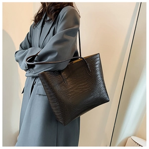 Detailed close-up of glossy black crocodile embossed texture on a large tote bag