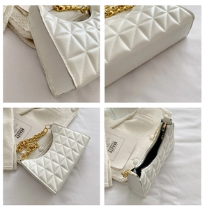 Detail view of white quilted underarm bag with gold chain strap and spacious interior