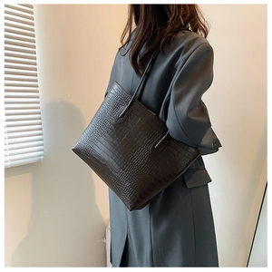 Close-up of crocodile pattern tote bag in dark brown with textured leather details