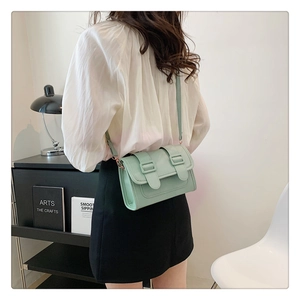 Detailed side view of mint green matte PU leather crossbody bag with double buckle straps