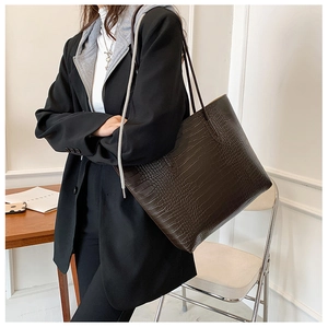 Detail of deep brown crocodile pattern tote bag showing high-quality texture and shoulder straps