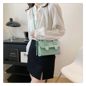 Detail view of mint green crossbody square bag with stylish vertical strap accents