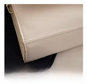 Close-up of precise stitching and gold-tone hardware on the cream leather handbag