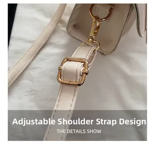 Detail of adjustable cream faux leather shoulder strap with polished gold metal hardware
