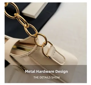 Close-up of golden chunky chain hardware and smooth cream leather on a shoulder bag