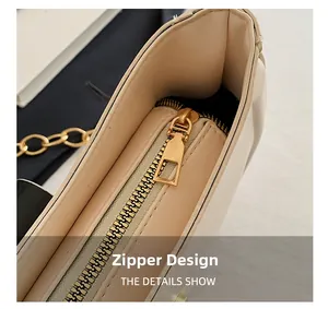 Detail view of smooth apricot leather bag with gold zipper closure and metal chain