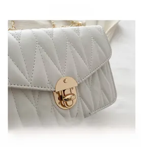 Détail du sac matelassé blanc en similicuir avec coutures en V et fermoir doré chic