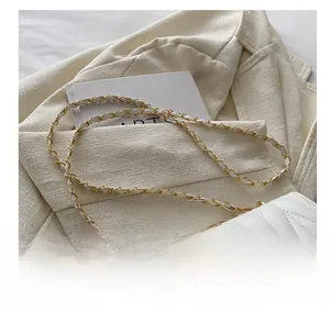 Vue détaillée du sac matelassé blanc avec boucle dorée et bandoulière en chaîne