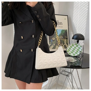 White quilted hobo bag with gold chain strap shown on black blazer dress outfit