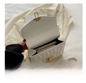 Détail du sac matelassé blanc à chaîne avec fermoir doré et espace intérieur pour téléphone