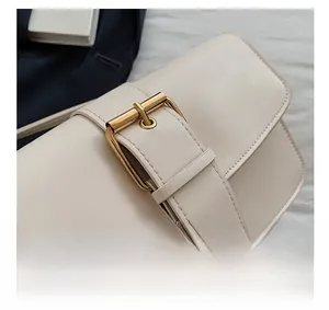 Détails de sac à bandoulière en cuir crème avec une boucle carrée dorée décorative