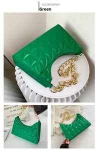 Detail of green quilted handbag with diamond pattern and gold chain strap