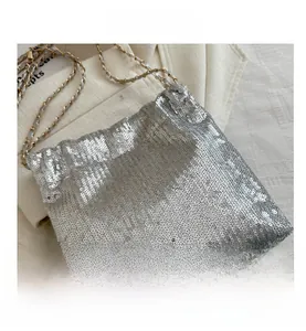 Close-up of sparkling silver sequin bucket bag featuring a woven metal chain strap