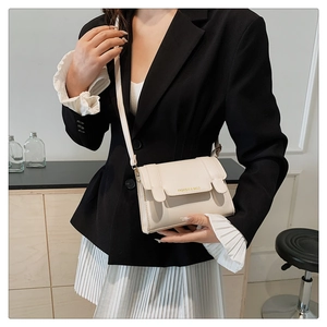 Detail of off-white crossbody bag with gold Fashion & Bags print on the front flap