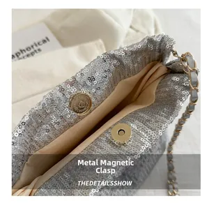 Detail of silver sequin bucket bag featuring magnetic snap closure and chain strap