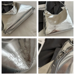 Détail du sac seau argenté métallisé avec lettrage embossé et bandoulière en chaîne
