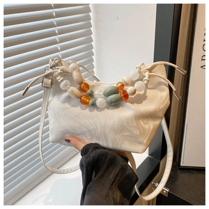 Detail of white marble-pattern leather tote bag with chunky bead handle design