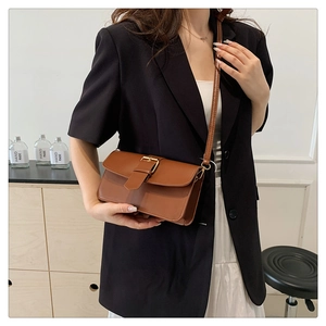Détail du sac bandoulière caramel avec fermoir carré en métal doré et fine bandoulière