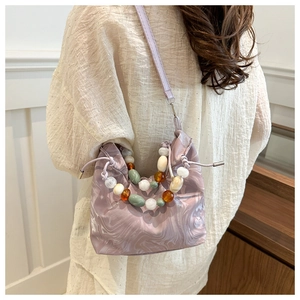 Elegant light purple bucket bag with marble print and beaded handle shown on model
