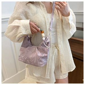 Detail of lavender marble texture bag with beaded handle and elegant pleated design