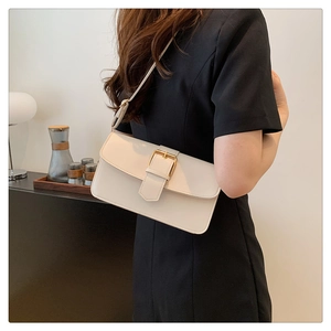 Détail d'un sac sous les aisselles beige avec boucle dorée sur un modèle