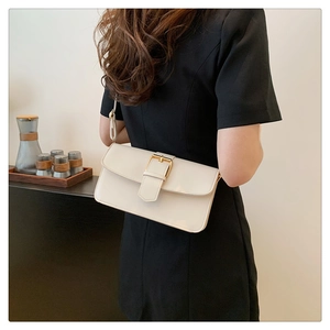Détail d'un sac sous le bras blanc cassé minimaliste avec boucle en métal doré rétro