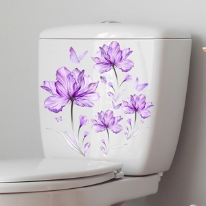 Détail de stickers fleurs mauves et papillons sur un réservoir de toilettes en céramique