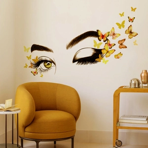 Minimalist wall sticker with female eyelashes and colorful butterflies in a cozy living room